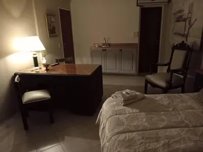a bedroom with a desk and a bed and a table and chair at Spilimbergo's Home in Cordoba