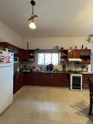 a kitchen with wooden cabinets and a white refrigerator at Mansion de Potrero in La Estancia