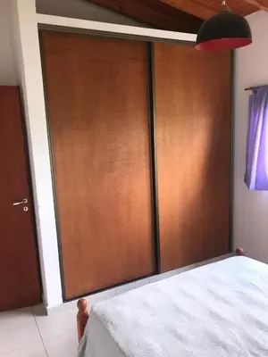 a large wooden door in a room with a bed at Cabañas Luciano in Arroyo de Los Patos