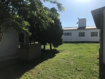 a white building with a tree in the yard at Cabañas Luciano in Arroyo de Los Patos
