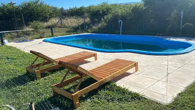 a pool with a bench and a picnic table next to it at Cabañas Luciano in Arroyo de Los Patos