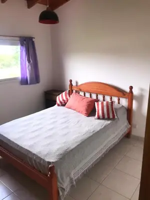 a bedroom with a bed with two pillows on it at Cabañas Luciano in Arroyo de Los Patos
