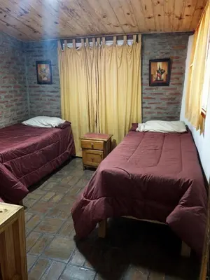 a bedroom with two beds and a wooden ceiling at La Rustica in El Durazno
