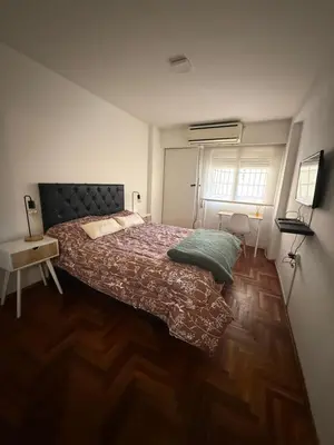 a bedroom with a large bed and a wooden floor at Balcones del Calicanto in Cordoba