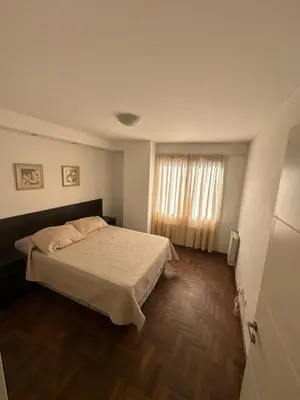 a bedroom with a large bed and a window at Departamento Galeria Strada in Villa Carlos Paz