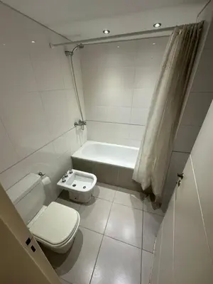 a bathroom with a toilet and a bath tub at Departamento Galeria Strada in Villa Carlos Paz
