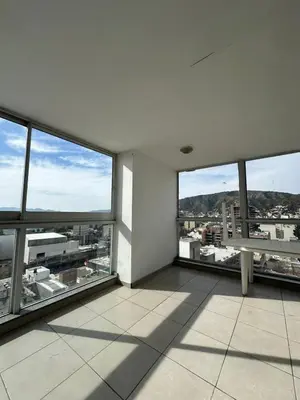 an empty room with large windows in a building at Departamento Galeria Strada in Villa Carlos Paz