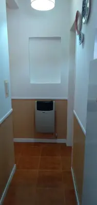 a hallway with a room with a television and a floor at La Colonial Cabañas in Villa Cura Brochero