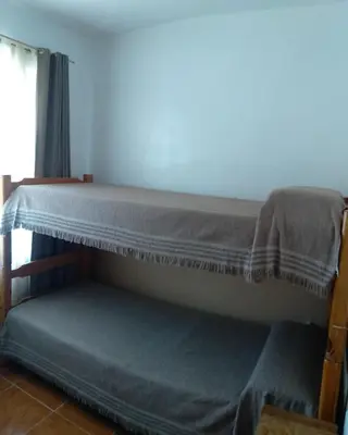 a bunk bed in a room with a blue mattress at La Colonial Cabañas in Villa Cura Brochero