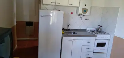 a kitchen with a white refrigerator and a sink at La Colonial Cabañas in Villa Cura Brochero