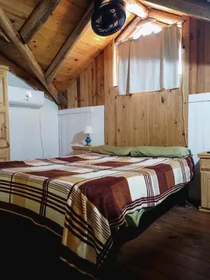 a large bed in a room with wooden walls at Casa VD in Santa Rosa de Calamuchita
