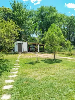 a path leading to a house with a car parked in a yard at Casa VD in Santa Rosa de Calamuchita