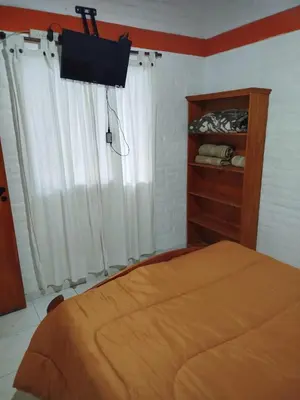 a bedroom with a bed and a window with a television at Cabañas del Puente - Rio Grande San Luis in La Bajada