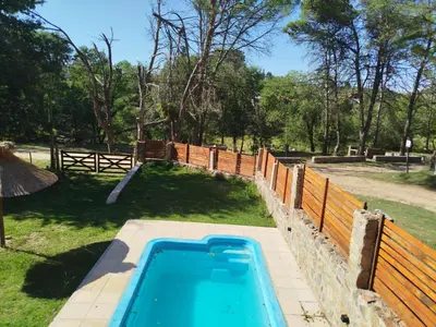 a swimming pool in a yard with a fence at Cabañas del Puente - Rio Grande San Luis in La Bajada