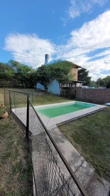 a tennis court in a yard with a fence at Casa Cedro Azul II in Villa Carlos Paz