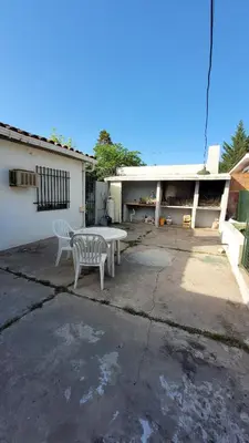 a table and two chairs in front of a house at Casa Cedro Azul II in Villa Carlos Paz