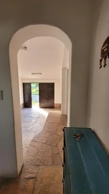 a room with a table and a hallway with a door at Casa Cedro Azul II in Villa Carlos Paz