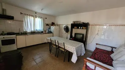 a kitchen with a table and a table and chairs at Casa Cedro Azul II in Villa Carlos Paz