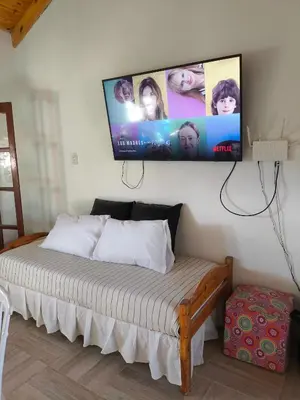 a bedroom with a bed with a flat screen tv on the wall at Las Carolas in Santa María