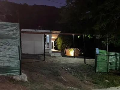 a small house at night with a fence in front of it at Monarcas III in Villa Carlos Paz