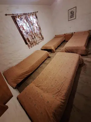 four beds in a room with a window at CASA EN VILLA LA BOLSA, Córdoba in Cordoba