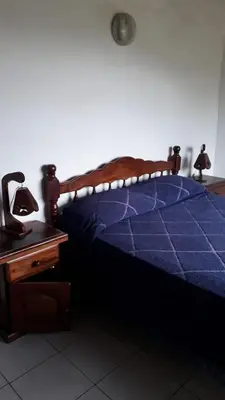 a bedroom with a bed with a blue comforter and a table at Estancia la aguada in Embalse