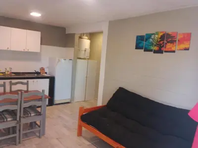 a living room with a couch and a kitchen at Cabaña Calamuchita Rumipal in Villa Rumipal