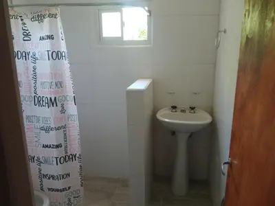 a bathroom with a sink and a shower curtain at Cabaña Calamuchita Rumipal in Villa Rumipal