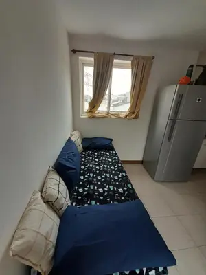a couch in a room with a window and a refrigerator at Los gigantes posada in Villa Carlos Paz