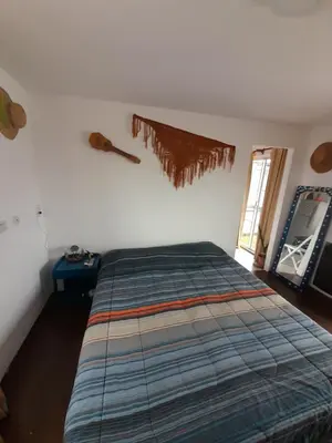 a bedroom with a bed and a guitar on the wall at Los gigantes posada in Villa Carlos Paz