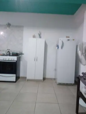 a kitchen with white cabinets and a refrigerator at Olga Carlos paz in Villa Carlos Paz