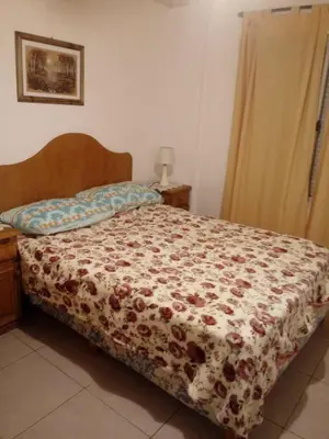 a bedroom with a bed with a floral bedspread at Olga Carlos paz in Villa Carlos Paz