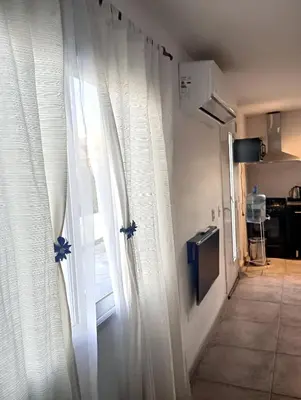 a room with a window with white curtains at Departamento zona estadio Kempes in Cordoba
