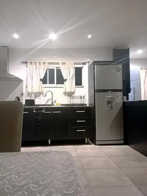 a kitchen with a refrigerator and a sink at Departamento zona estadio Kempes in Cordoba