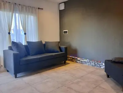a blue couch sitting in a living room at Departamento zona estadio Kempes in Cordoba