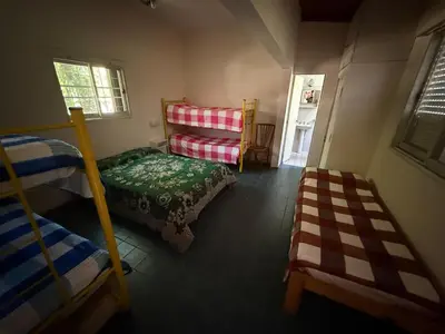 a bedroom with bunk beds and a bed and a window at Nuevo complejo Clarita in Villa Carlos Paz