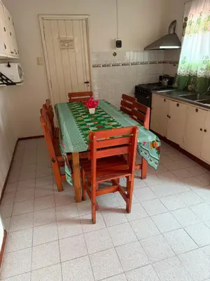 a kitchen with a table with chairs and a tableablish at Nuevo complejo Clarita in Villa Carlos Paz