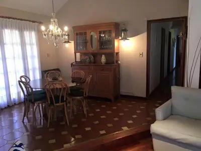 a dining room with a table and chairs and a chandelier at Casa alquiler Villa Carlos Paz in Villa Carlos Paz