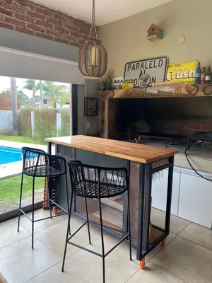 a table and two chairs in a room with a pool at Casa alquiler Villa Carlos Paz in Villa Carlos Paz