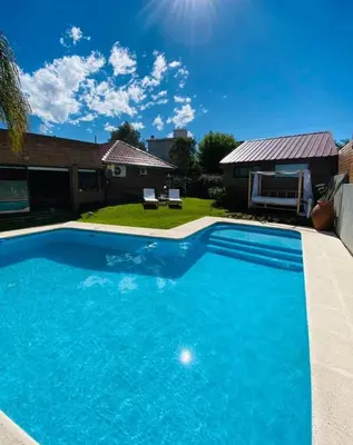 a large blue swimming pool in front of a house at Casa alquiler Villa Carlos Paz in Villa Carlos Paz
