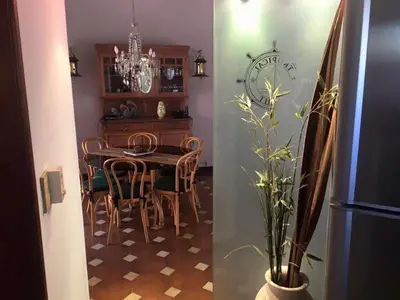 a dining room with a table and chairs and a refrigerator at Casa alquiler Villa Carlos Paz in Villa Carlos Paz
