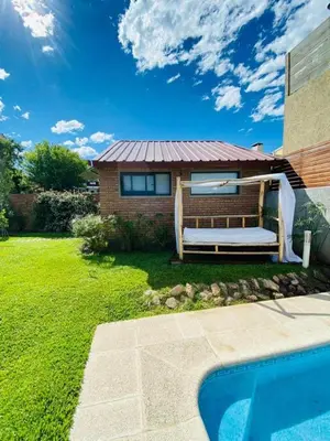 a house with a bench next to a swimming pool at Casa alquiler Villa Carlos Paz in Villa Carlos Paz