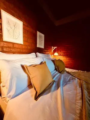 a bed with white sheets and pillows in a room at Cabañas Los Tinos in Carpintería