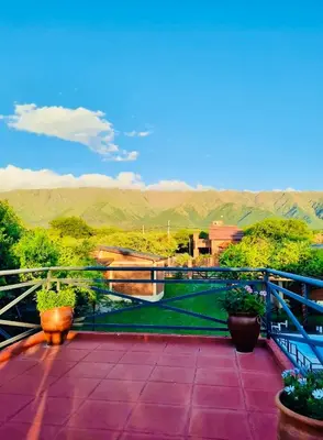 a balcony with potted plants and a view of mountains at Cabañas Los Tinos in Carpintería