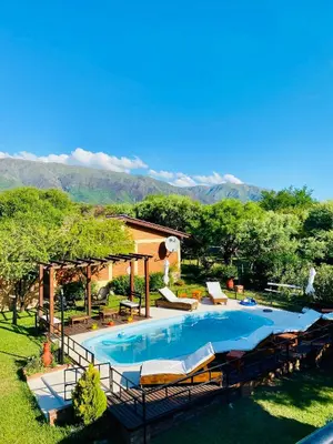 a large swimming pool with chairs and a house at Cabañas Los Tinos in Carpintería