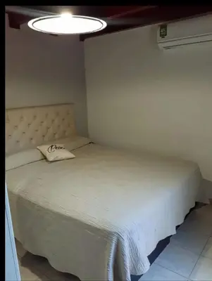 a bedroom with a white bed with a pillow on it at Sin nombre in Mina Clavero