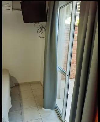 a room with a window with a curtain and a tile floor at Sin nombre in Mina Clavero