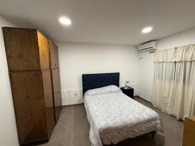 a bedroom with a bed and a wooden cabinet at house with garage in Cordoba