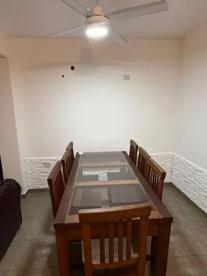 a dining room table with chairs and a ceiling fan at house with garage in Cordoba