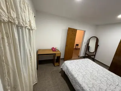 a bedroom with a bed and a table and a mirror at house with garage in Cordoba